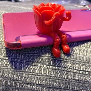 Red Rose-Shaped buddy sits with dangling legs holding up a heart sign 3D printed